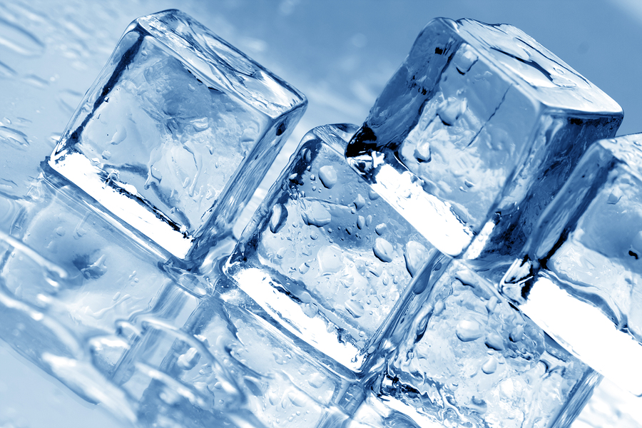 Melting ice cubes on a metal tabletop. blue reflective surface