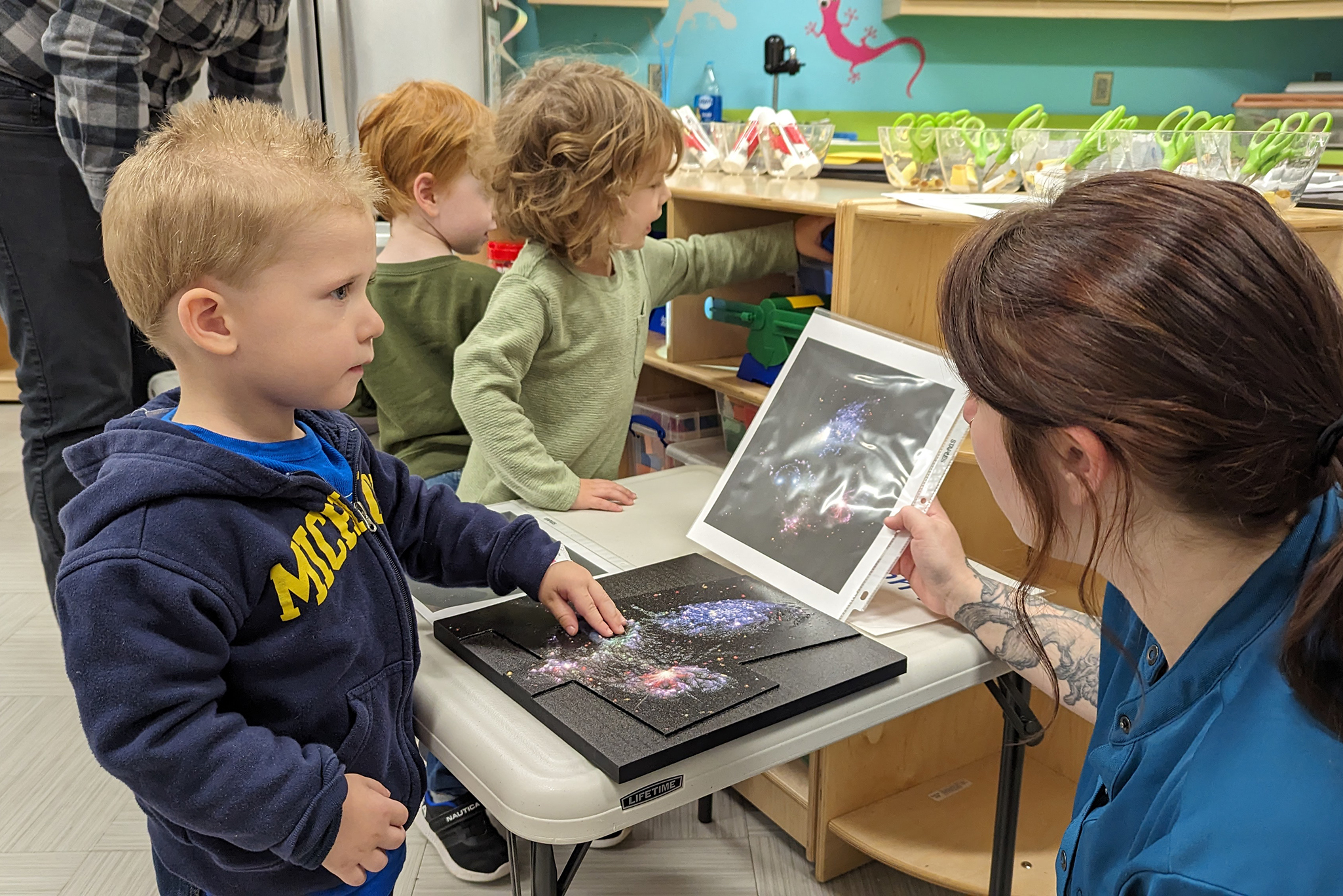 Toddler feeling a tactile representation of a galaxy